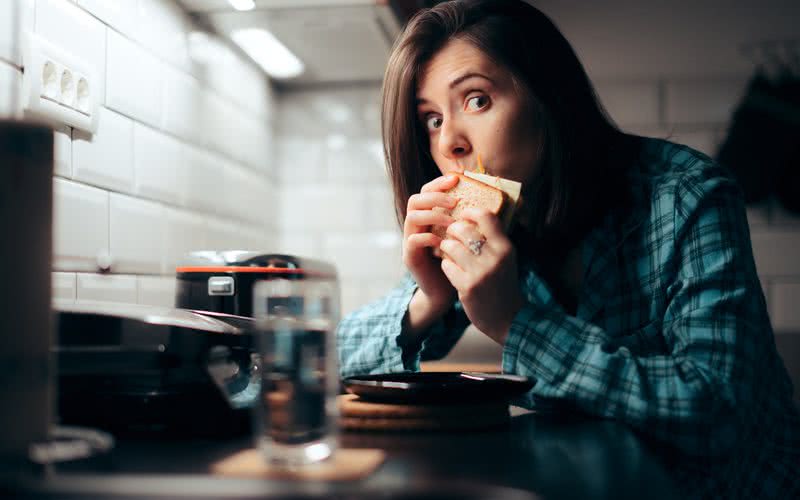 Comer com distrações, como televisão ou celular, pode fazer uma pessoa comer mais - iStock